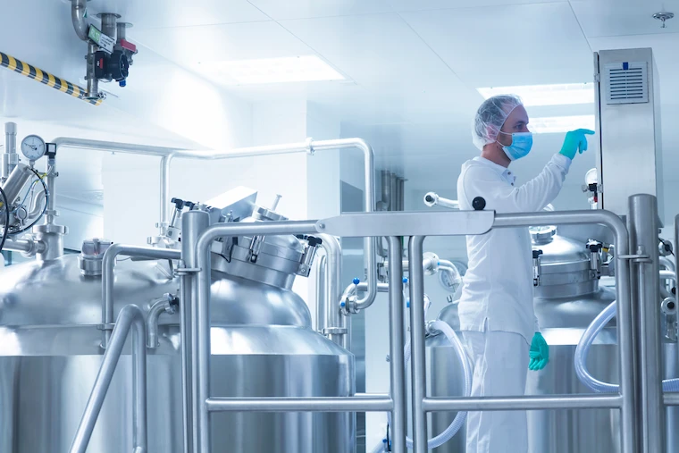 Pharmaceutical processing plant with stainless steel equipment and a technician